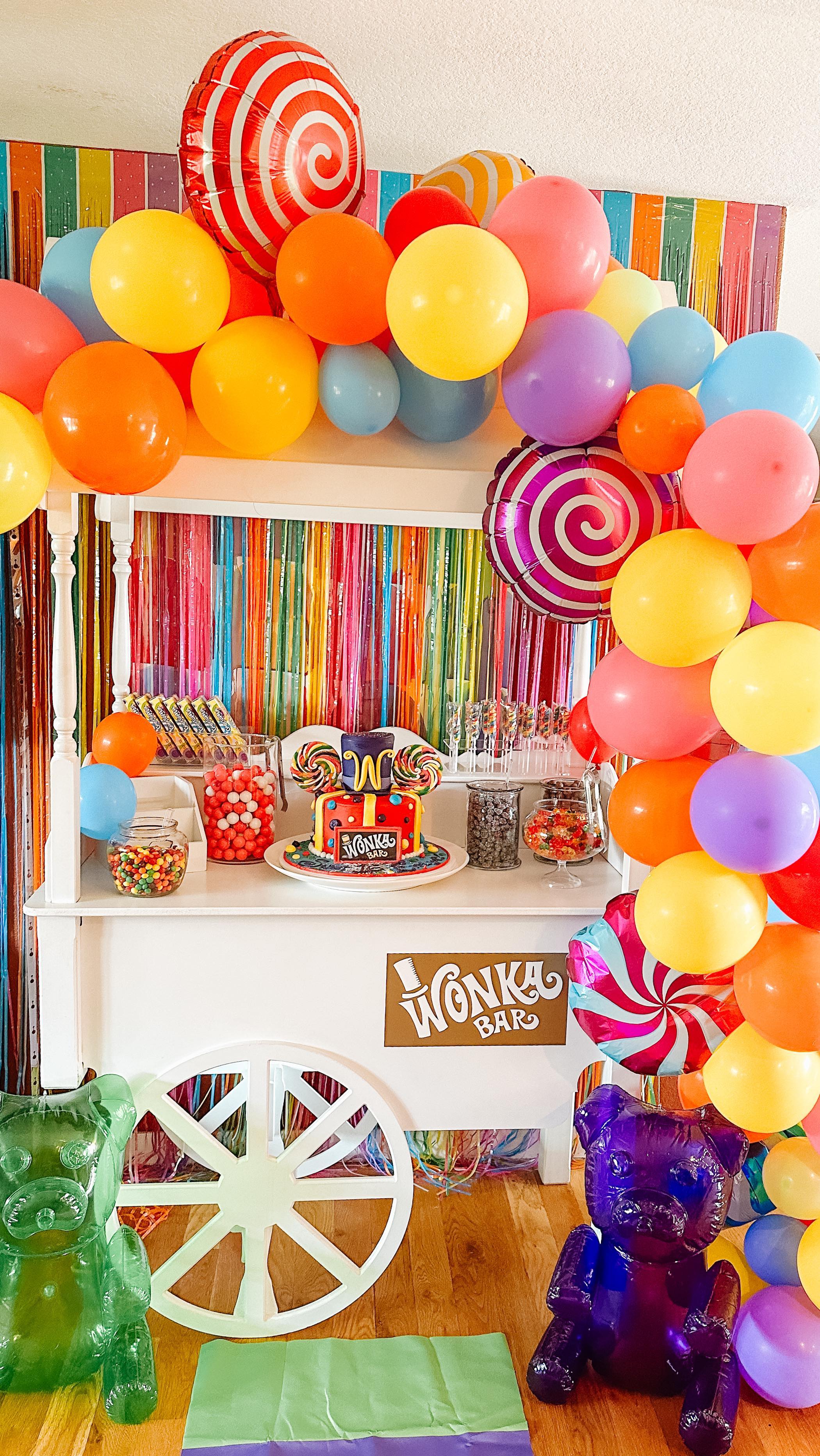 Wonka themed candy cart with colorful balloons